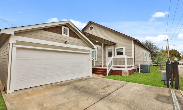 view of front of property with a garage, central air condition unit, and a front lawn