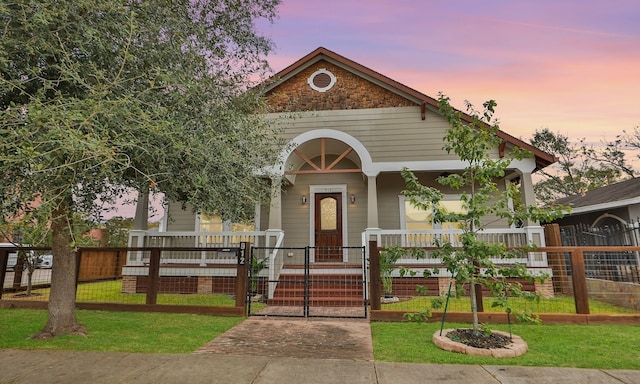 view of front of property with a lawn and a porch