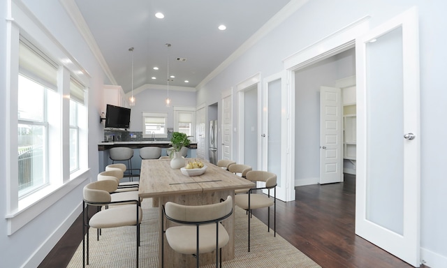 dining room featuring lofted ceiling, ornamental molding, and dark wood-type flooring