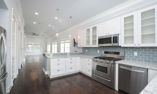 kitchen with appliances with stainless steel finishes, ceiling fan, decorative light fixtures, white cabinetry, and lofted ceiling