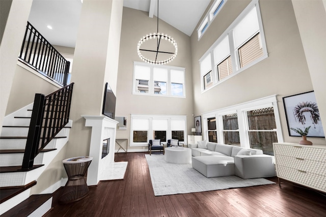 living room featuring a notable chandelier, dark hardwood / wood-style floors, and high vaulted ceiling