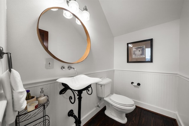 bathroom featuring toilet, wood-type flooring, and vaulted ceiling