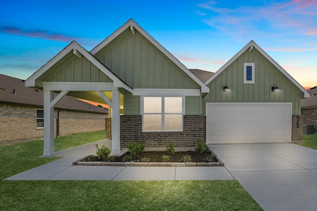 craftsman-style house featuring concrete driveway, a front lawn, brick siding, and board and batten siding
