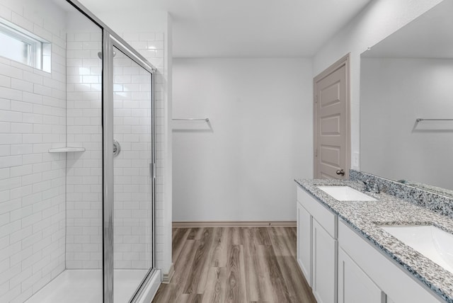 full bathroom with wood finished floors, a stall shower, and a sink