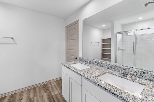 full bath featuring visible vents, wood finished floors, a stall shower, and a sink