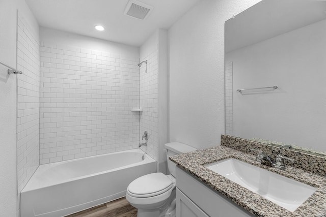 bathroom featuring toilet, tub / shower combination, wood finished floors, visible vents, and vanity