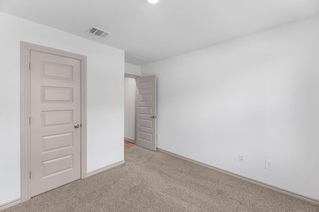 carpeted spare room featuring visible vents