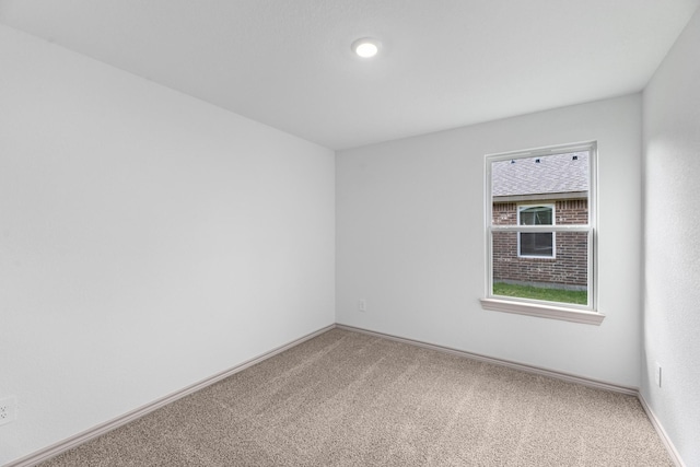empty room with baseboards and light carpet