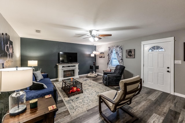 living room with dark hardwood / wood-style flooring and ceiling fan