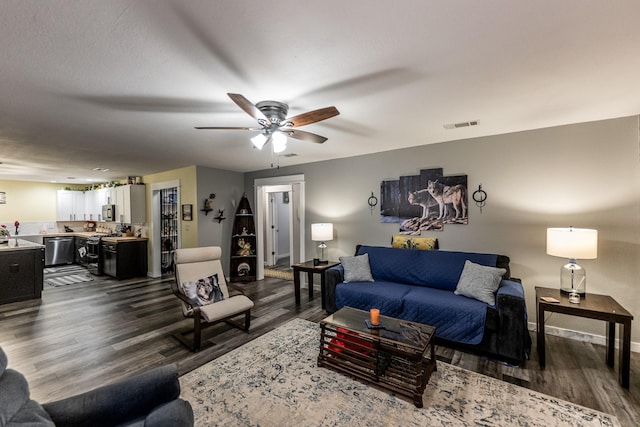 living room with ceiling fan and dark hardwood / wood-style flooring