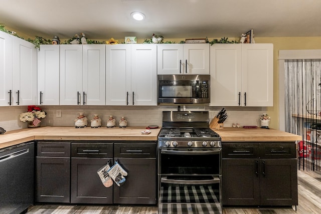 kitchen featuring backsplash, white cabinetry, stainless steel appliances, and light wood-type flooring