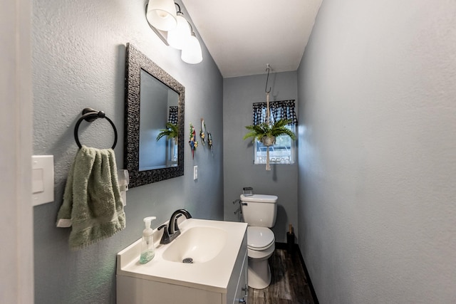 bathroom with hardwood / wood-style flooring, vanity, and toilet