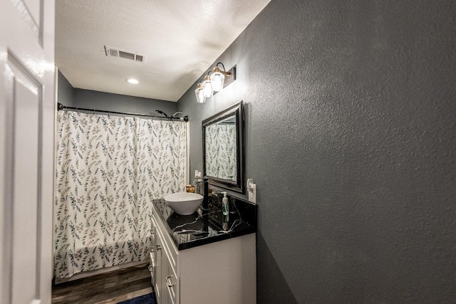 bathroom with hardwood / wood-style flooring, vanity, and shower / tub combo with curtain