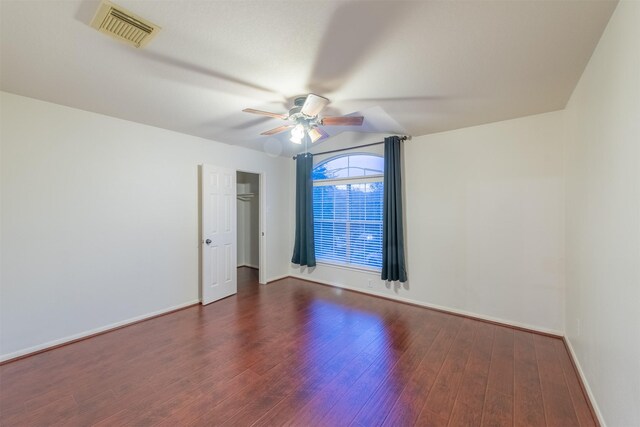 empty room with ceiling fan and dark wood-type flooring