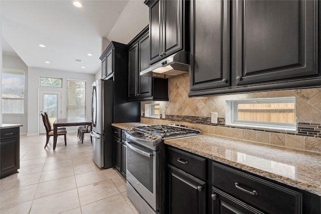 kitchen featuring decorative backsplash, light tile patterned floors, stainless steel appliances, and light stone countertops