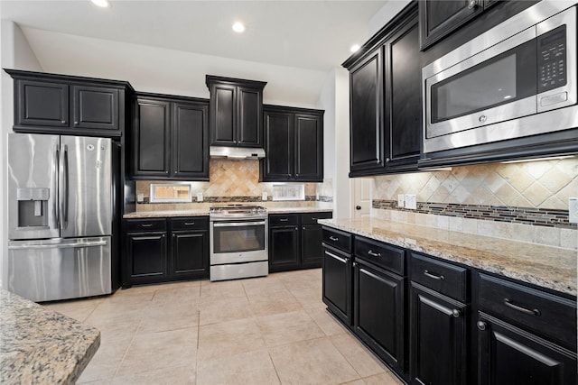 kitchen featuring tasteful backsplash, light stone countertops, light tile patterned floors, and stainless steel appliances