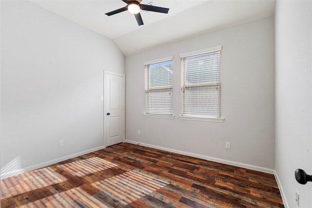 empty room with dark hardwood / wood-style flooring, vaulted ceiling, and ceiling fan