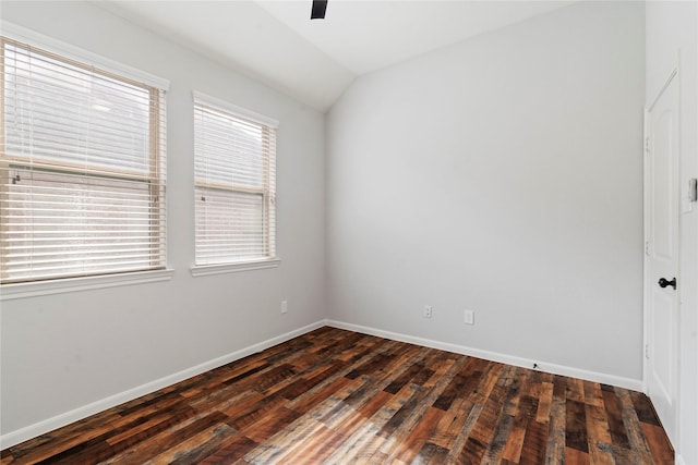 spare room with dark hardwood / wood-style flooring and lofted ceiling