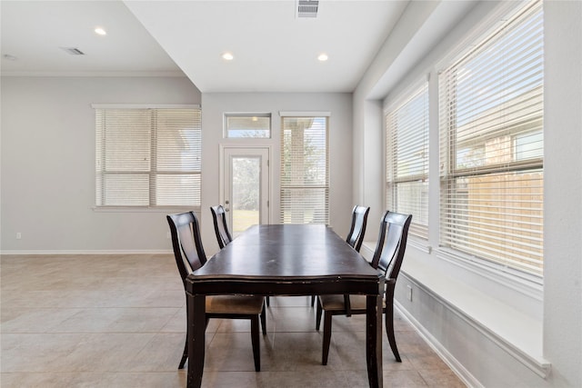 tiled dining area with a wealth of natural light and crown molding