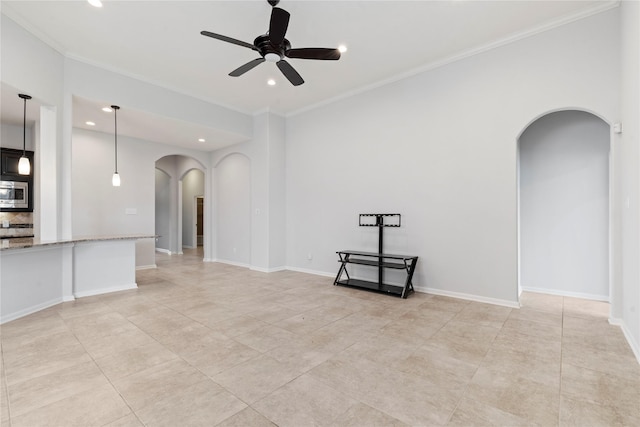 unfurnished living room with ceiling fan and ornamental molding