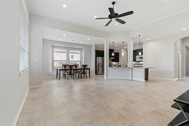 kitchen with light stone counters, ornamental molding, stainless steel appliances, ceiling fan, and decorative light fixtures