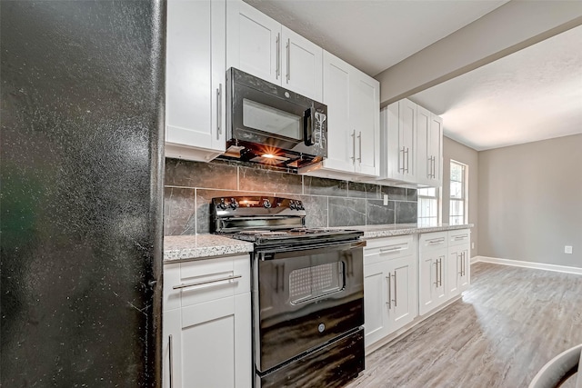 kitchen featuring light stone countertops, light wood-type flooring, backsplash, black appliances, and white cabinets