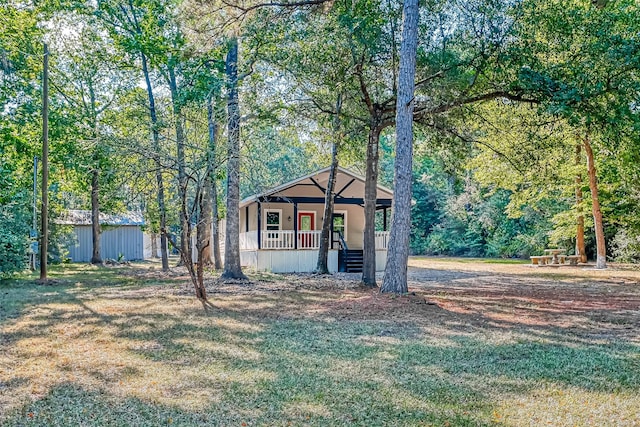 view of front of property with covered porch and a storage shed