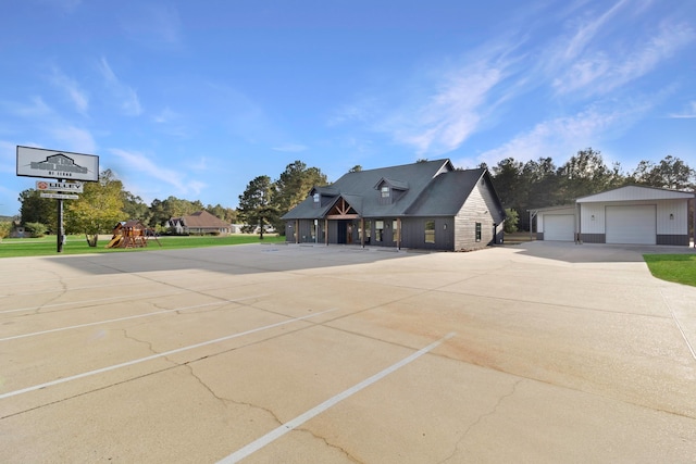 view of front of property with a playground and a garage