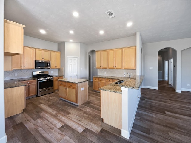 kitchen with kitchen peninsula, sink, stainless steel appliances, and dark hardwood / wood-style flooring