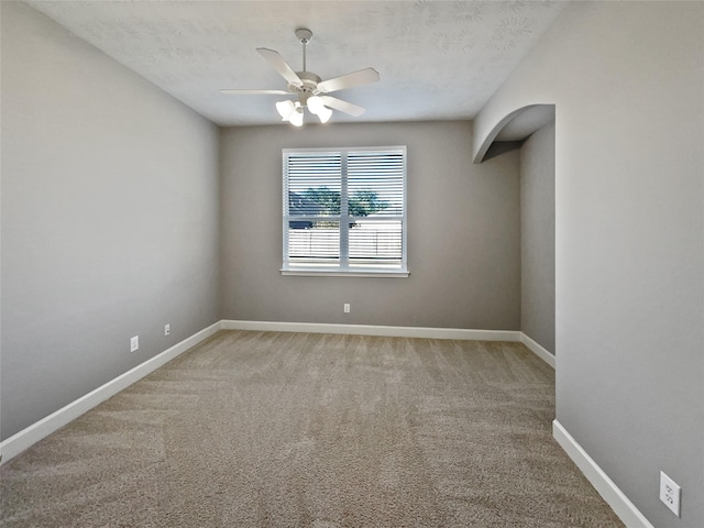 carpeted spare room featuring a textured ceiling and ceiling fan