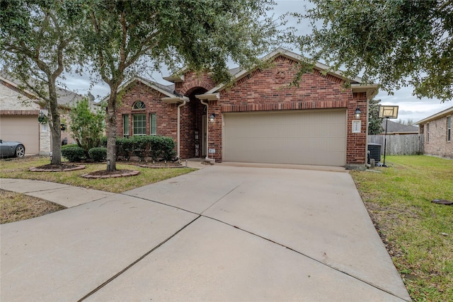 view of front of property with a front yard, a garage, and central AC unit