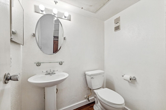 bathroom with hardwood / wood-style floors and toilet