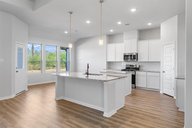 kitchen featuring white cabinetry, a kitchen island with sink, sink, and appliances with stainless steel finishes