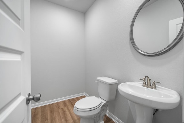 bathroom with sink, toilet, and hardwood / wood-style flooring