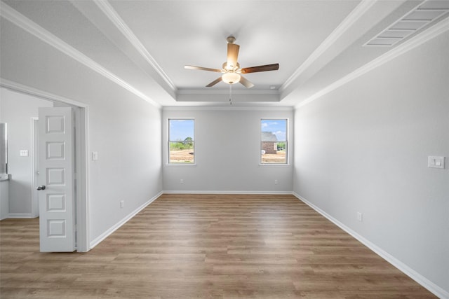 spare room featuring ceiling fan, crown molding, a tray ceiling, and light hardwood / wood-style flooring