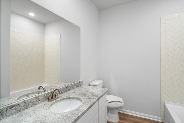 full bathroom featuring wood-type flooring, vanity, toilet, and tiled shower / bath