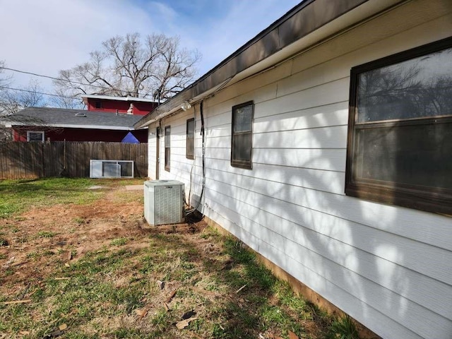 view of side of home featuring central air condition unit and a yard