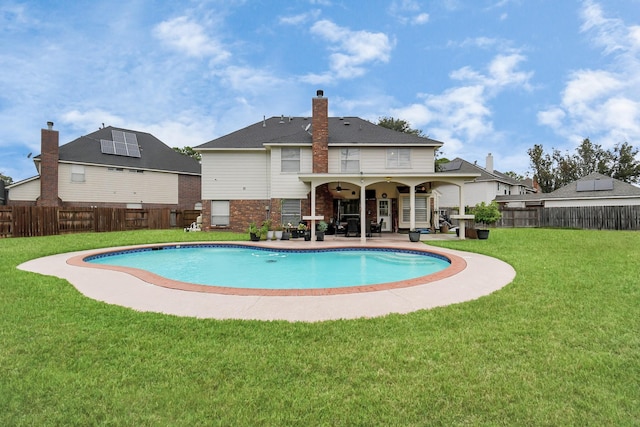 view of swimming pool featuring ceiling fan, a patio area, and a lawn