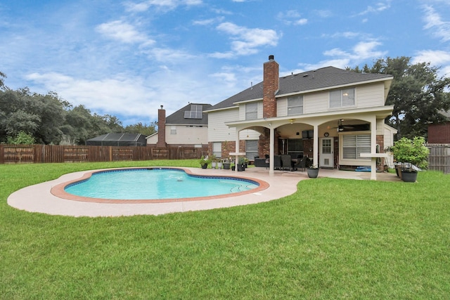 view of pool with a lawn, ceiling fan, and a patio