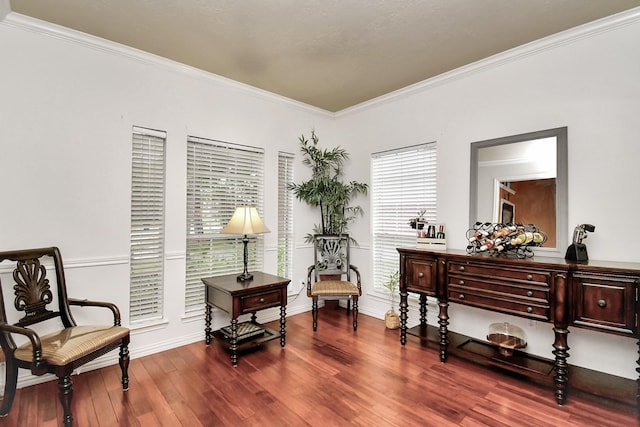 living area with wood-type flooring and ornamental molding