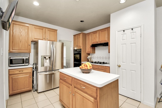 kitchen with appliances with stainless steel finishes, a center island, tasteful backsplash, and light tile patterned floors