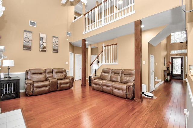 living room with hardwood / wood-style floors and a towering ceiling