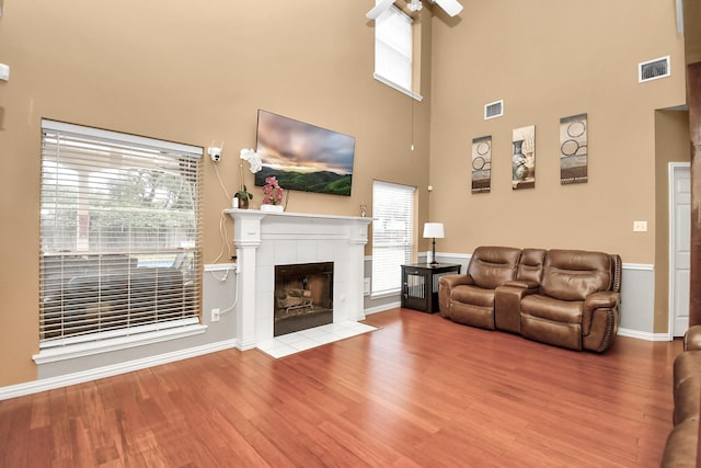 living room with hardwood / wood-style floors, plenty of natural light, and a tile fireplace