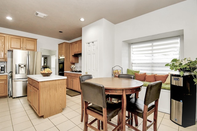 kitchen featuring a kitchen island, stainless steel appliances, and light tile patterned floors