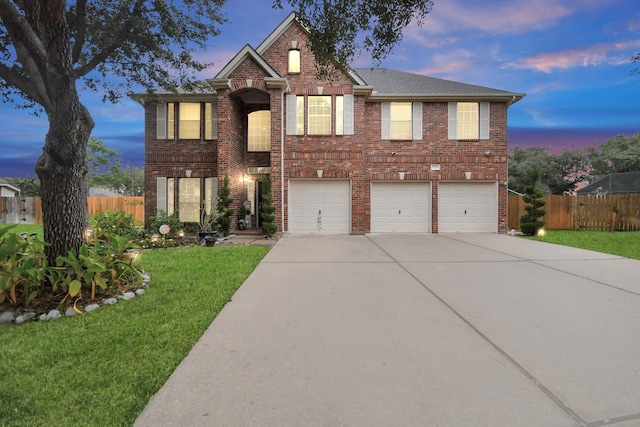 view of front of house with a garage and a lawn