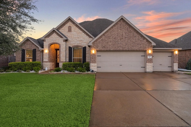 view of front of house featuring a garage and a yard