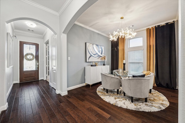 dining area with dark hardwood / wood-style floors, crown molding, and an inviting chandelier