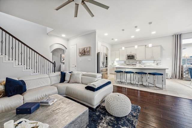 living room featuring ceiling fan, light hardwood / wood-style flooring, and crown molding