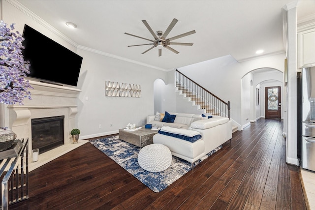 living room with wood-type flooring, ceiling fan, and ornamental molding