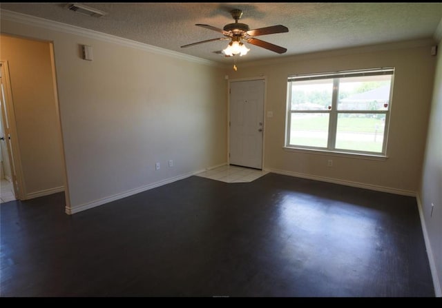 tiled empty room featuring a textured ceiling, ceiling fan, and ornamental molding